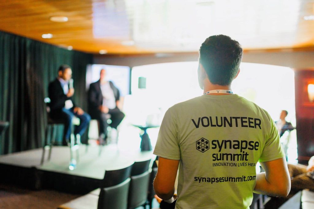 Synapse volunteer standing in conference room